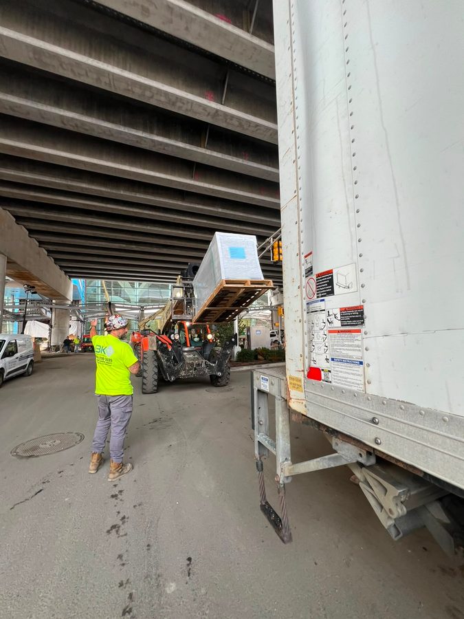 Freight being loaded into a trailer by crane, different angle